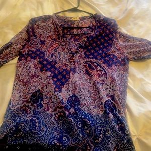 Quarter sleeve woman’s dress shirt . Low cut V neck with closable buttons.